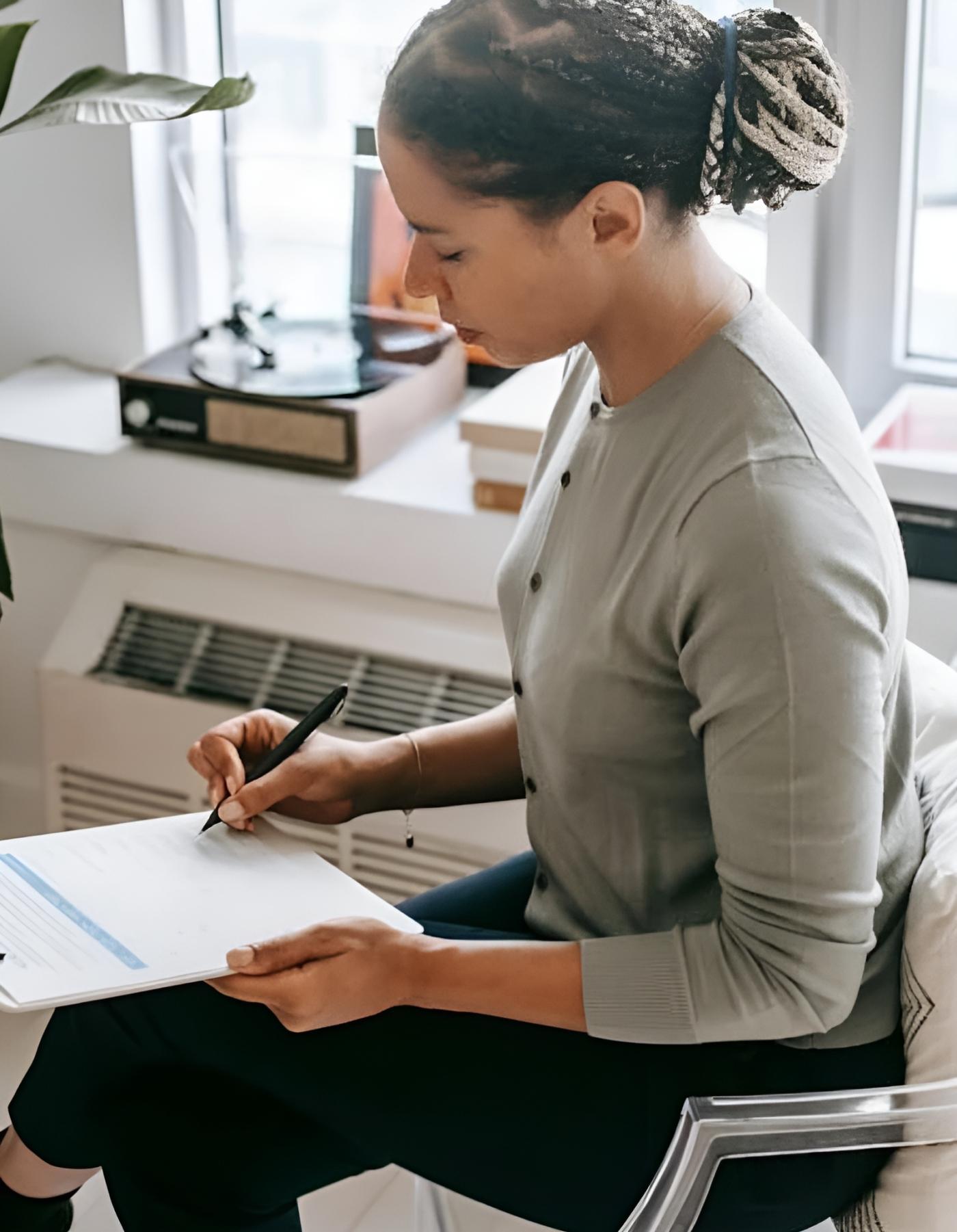 woman writing on clip board