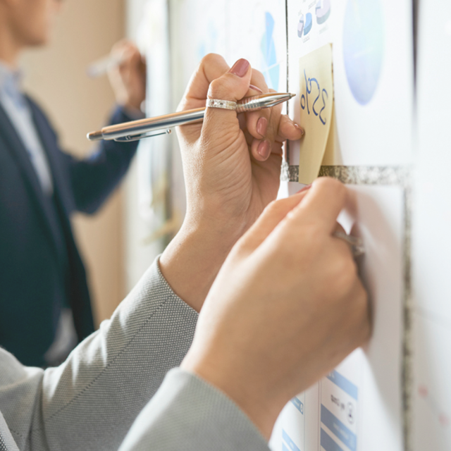 People writing on sticky notes